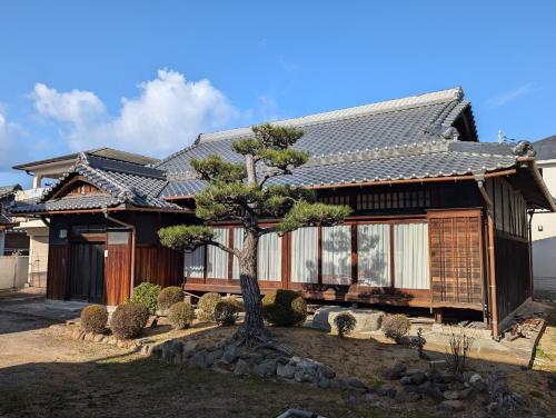 a house with a tree in front of it at YASUZAIMON - Vacation STAY 18478 in Kaizuka