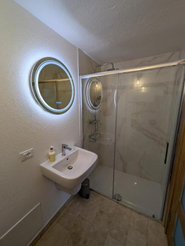 a bathroom with a sink and a shower with a mirror at La Casa Della Seta in Mezzegra