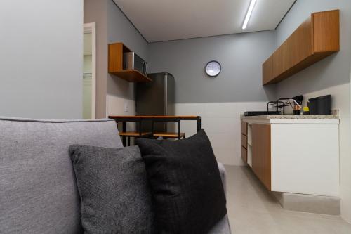 a living room with a couch and a kitchen at 360 Sanfran Riachuelo in Sao Paulo