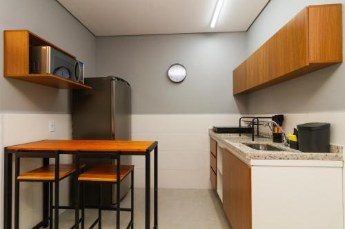 a kitchen with a counter and a sink and a refrigerator at 360 Sanfran Riachuelo in Sao Paulo