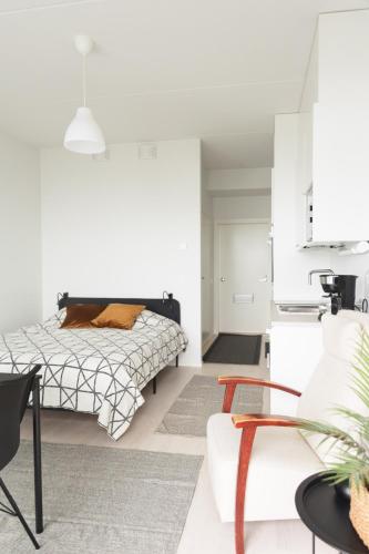 a bedroom with a bed and a living room at Framnäs Suites in Kirkkonummi
