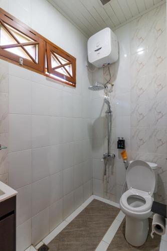 a bathroom with a toilet and a shower in it at Belgareti Modern Ethnic House Cipanas Puncak in Cibadak