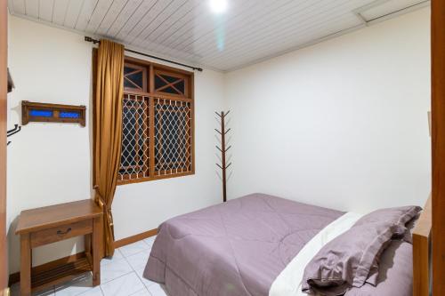 a bedroom with a bed and a window at Belgareti Modern Ethnic House Cipanas Puncak in Cibadak