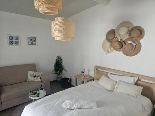 a bedroom with a bed and a couch and hats on the wall at Quinta do Lidador in Chamusca