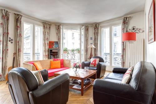 - un salon avec des fauteuils en cuir et une table dans l'établissement Family Apartment - MON AMOUR - Close all you need- Cosy Modern & Comfort - FREE PARIS Travel GUIDE, à Paris