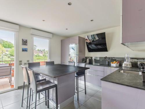 une cuisine avec un grand îlot et des tabourets de bar dans l'établissement appartement idéalement situé, à Annecy