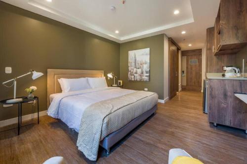 a bedroom with a large bed and a kitchen at El Tesoro Medellín Hab311 by Letoh in Medellín
