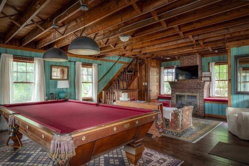a room with a pool table and a fireplace at Stay at Little River in Gloucester