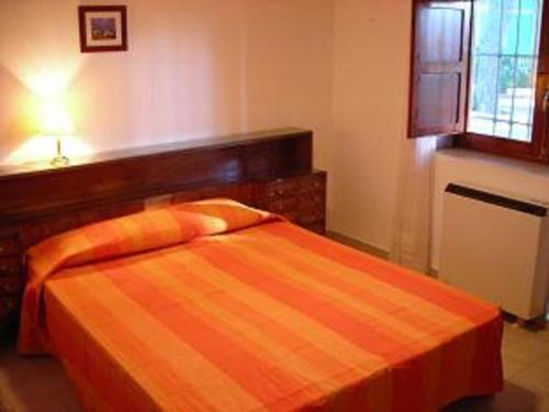 a bedroom with a bed with an orange blanket at Casica de Hellín in Hellín
