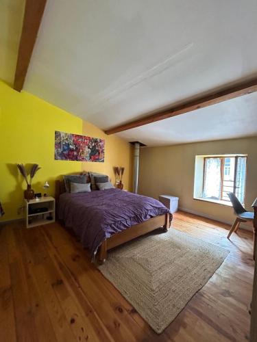 - une chambre avec un lit et un mur jaune dans l'établissement Duplex spacieux 6p avec bar et garage, à Tournon-sur-Rhône