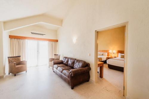 a living room with a couch and a bed at Comfort Inn Puerto Vallarta Golfside & Marina in Puerto Vallarta
