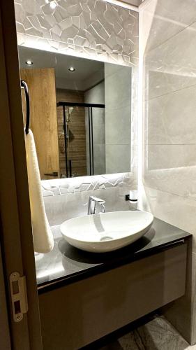 a bathroom with a sink and a large mirror at Elite Luxury Suites at The Diamond in City in Cantonments