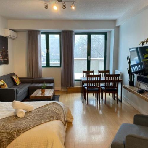 a living room with a couch and a table and chairs at Appartement Sur la "Main" in Montréal