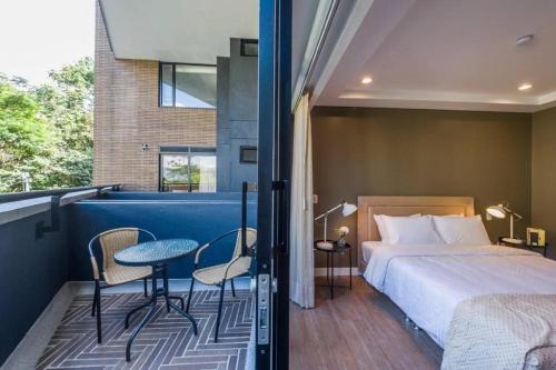 a bedroom with a bed and a table and chairs at El Tesoro Medellín Hab311 by Letoh in Medellín
