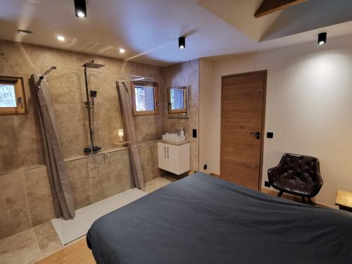 - une chambre avec une douche, un lit et une chaise dans l'établissement Appartement-Plateau d'Assy, à Passy