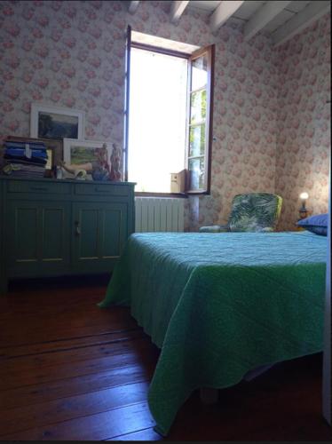une chambre avec un lit vert et une fenêtre dans l'établissement Maison Fongrave, à Fongrave