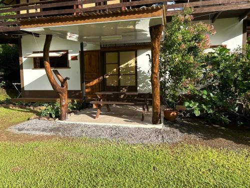a house with a bench in front of it at Ana Lodge Tepua in Uturoa