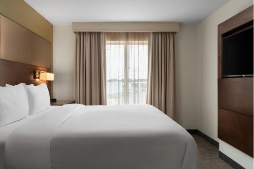 a hotel room with a large white bed and a window at Residence Inn by Marriott Kingston in Kingston
