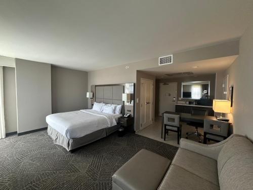 a hotel room with a bed and a desk at Embassy Suites by Hilton Kansas City Olathe in Olathe
