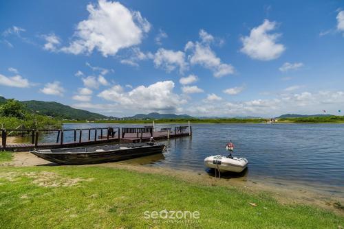 a boat is docked at a dock on a lake at Apto com Vista Mar a 214m da Praia - BLU0206 in Florianópolis