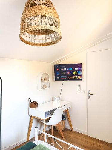 Cette chambre comprend un bureau et un lustre. dans l'établissement Escapade Méditerranéenne chez Patricia et Roger, à Jacou