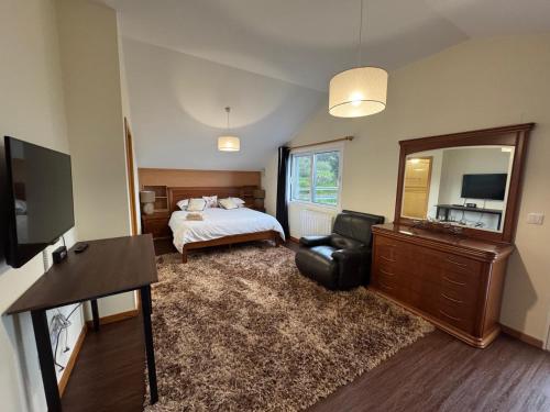 a bedroom with a bed and a chair and a mirror at Prazeres Natura in Prazeres