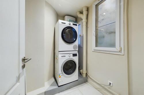 La salle de bains est pourvue d'un lave-linge et d'un sèche-linge. dans l'établissement Superbe appartement tout équipé au coeur de Levallois !, à Levallois-Perret