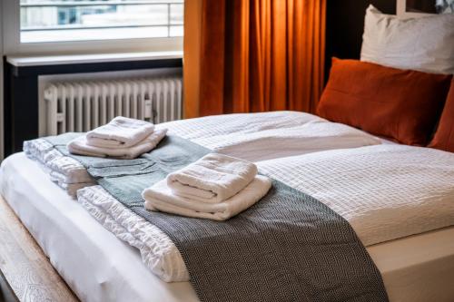 two towels are sitting on top of a bed at Klassen Stay - Design Apartments direkt am HBF Aachen in Aachen