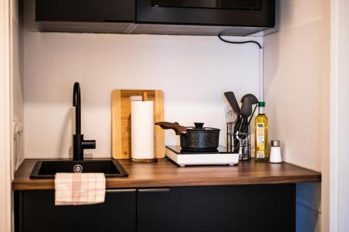 a kitchen counter top with a sink and a stove at Klassen Stay - Design Apartments direkt am HBF Aachen in Aachen
