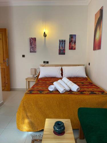 a bedroom with a large bed with towels on it at Dyafat Abla in Ouarzazate