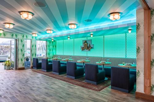 a restaurant with blue walls and tables and chairs at Marina del Rey Hotel in Los Angeles