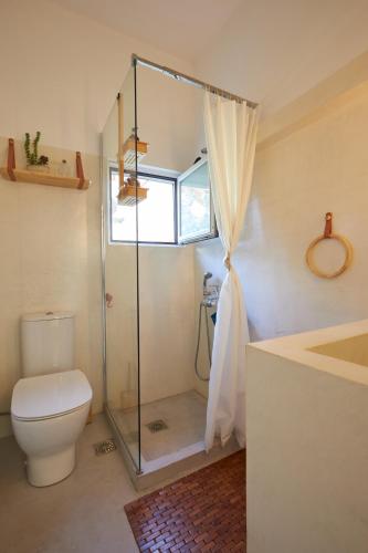 a bathroom with a toilet and a glass shower at Camara Athens Riviera Home in Aghia Marina