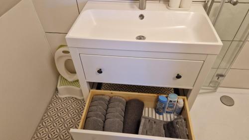 a bathroom with a sink and a drawer with towels at Gästezimmer mit Himmel-Blick 4 Two in Nürnberg