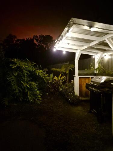 a lit up pergola in a yard at night at Pu'uwai Place of Volcano Village in Volcano