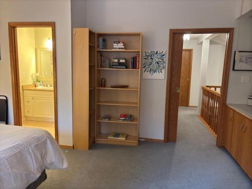a bedroom with a bed and a bathroom with a mirror at Bayview Bed and Breakfast in Mill Bay