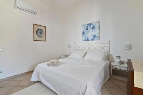 - une chambre blanche avec un lit blanc et une table dans l'établissement Sea View Apartment 90 m² in South Sardinia, à Villasimius