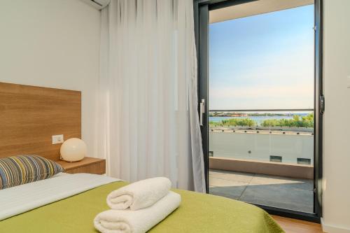 a bedroom with a bed with two towels on it at Beachfront Villa Jugo with Seaview in Privlaka