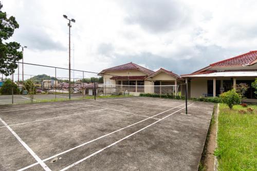 a tennis court in front of a building at Belgareti Modern Ethnic House Cipanas Puncak in Cibadak