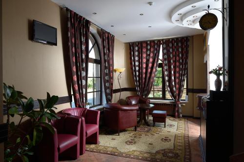 - une salle d'attente avec des chaises rouges et des fenêtres dans l'établissement Family Hotel Demetra, à Berkovitsa