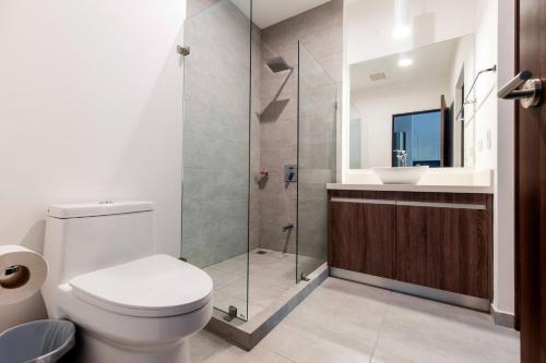 ein Badezimmer mit Toilette und Glasdusche in der Unterkunft Urban Flats Studios by Corporate Stays in San José