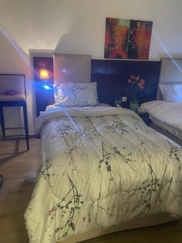 a bedroom with a bed with a comforter on it at Elegant private room with attached bathroom in Al Muwayqi‘ī