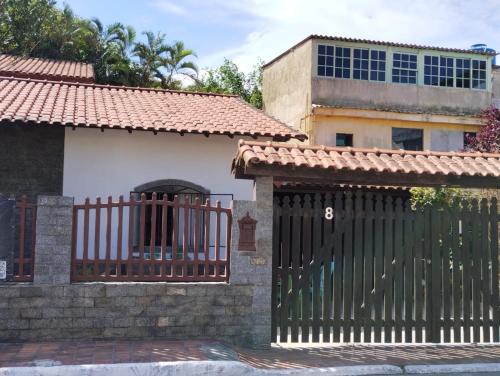 a gate in front of a house with a building at Recanto da Árvore Suítes e Café in Arraial do Cabo