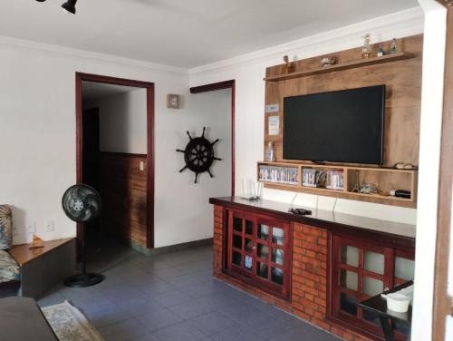 a living room with a flat screen tv on a wall at Recanto da Árvore Suítes e Café in Arraial do Cabo