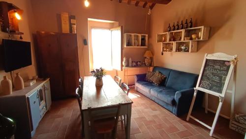 a living room with a blue couch and a table at Appartamento nel Borgo Cuore dell'Umbria, vicino ad Assisi in Gualdo Cattaneo