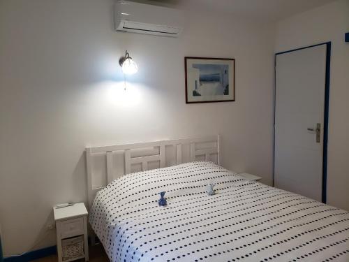 1 dormitorio con cama blanca y edredón blanco y negro en chez Marcel, en Rosières