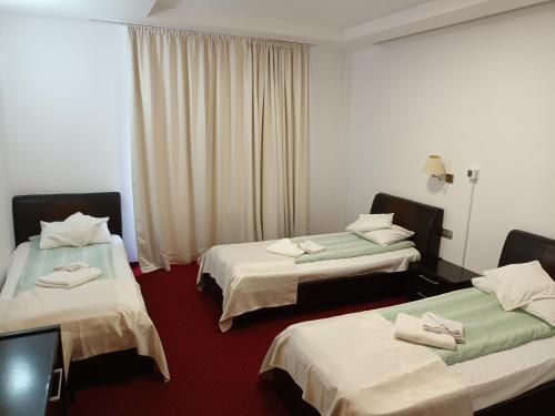 a hotel room with two beds with towels on them at Hotel Transilvania Zalău in Zalău