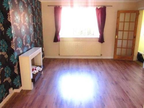 un soggiorno vuoto con ampia finestra e pavimenti in legno di Entire 3 Bedroom Furnished Home a Bolton