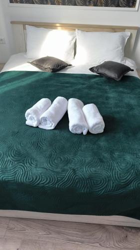 a bed with two white towels on a green blanket at Salin Gold Ap in Turda