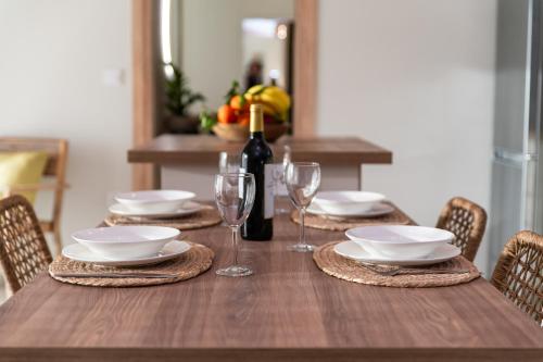 a wooden table with a bottle of wine and glasses at Villa Armeno in Vlachata