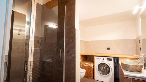 a bathroom with a shower and a washing machine at Appartamento Vale e Schena Cortina D'Ampezzo in San Vito di Cadore
